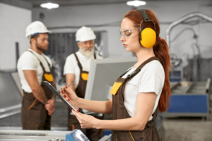 Cursos prevención riesgos laborales. Personas trabajando con auriculares y cascos